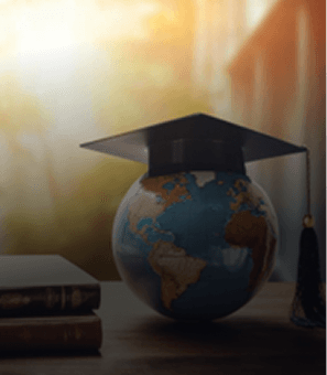 A graduation cap on a globe in warm sunlight